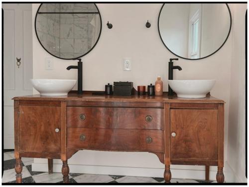 a bathroom with two sinks on a wooden dresser at Thames Home in Taylor