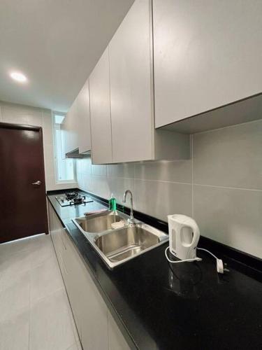 a kitchen with a sink and white cabinets at Ksl C2 3R3B 1-5pax #Daya#Austin#Ikea#Aeon in Johor Bahru