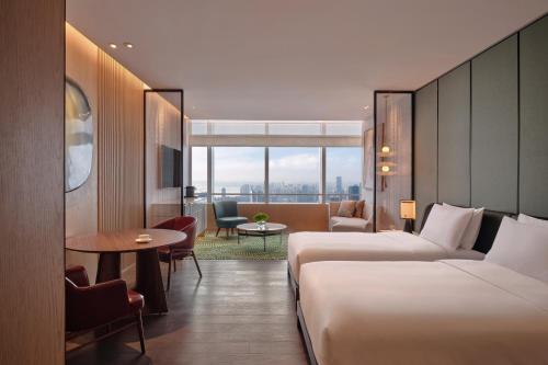 a hotel room with two beds and a table at Park Hyatt Changsha in Changsha