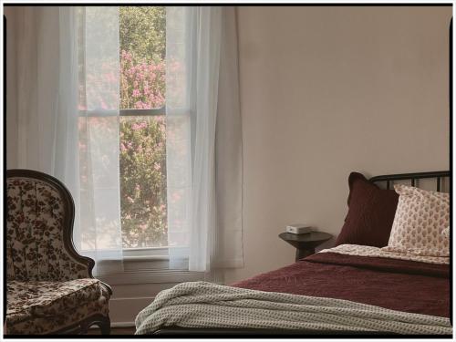 a bedroom with a bed and a window with flowers at Thames Home in Taylor