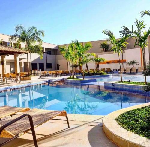 a pool at a resort with palm trees at Hotel boulevard caldas novas in Caldas Novas