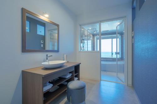 a bathroom with a sink and a mirror at Yahataya in Kanezaki