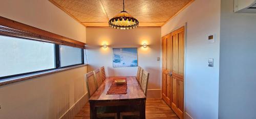 ein Esszimmer mit einem Holztisch und einem Fenster in der Unterkunft Riverview Holiday Apartment 15 - Kalbarri, WA in Kalbarri