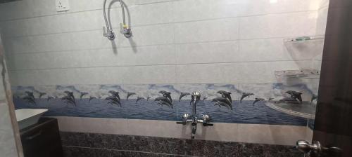 a bathroom with a flock of birds on the wall at Goenka Home Stay Barsana in Barsāna
