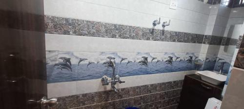 a bathroom with a shower with birds in the water at Goenka Home Stay Barsana in Barsāna