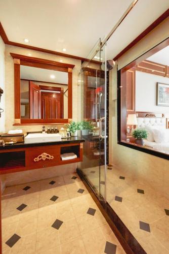 a bathroom with a glass shower and a sink at DLG Hotel Danang in Da Nang