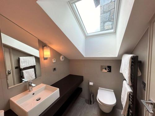 a bathroom with a sink and a toilet with a skylight at Appartement 5 pièces avec balcon et garage à Méribel - FR-1-180-624 in Les Allues