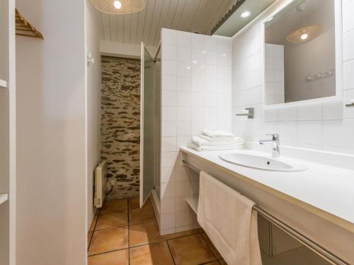 une salle de bain blanche avec un lavabo et un miroir dans l'établissement Maison avec piscine privée chauffée, proche plage à Pornic - FR-1-306-1284, à Pornic