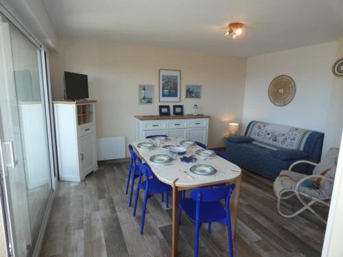 un salon avec une table et des chaises bleues dans l'établissement Appartement rénové, 2 chambres, balcon, parking, face mer - FR-1-540-295, à Notre-Dame-de-Monts