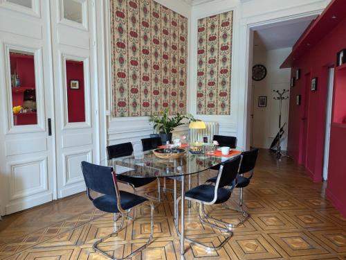 une salle à manger avec une table et des chaises en verre dans l'établissement Appartement avec terrasse, jardin et WIFI au cœur historique d'Angoulême - FR-1-653-263, à Angoulême