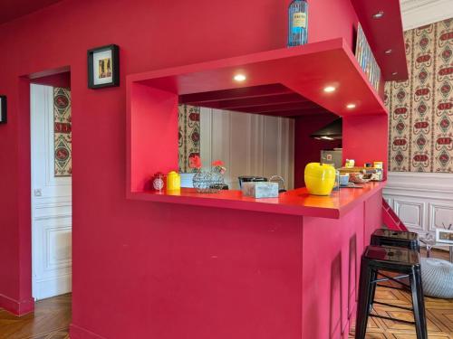 un mur rouge avec un comptoir rouge dans une pièce dans l'établissement Appartement avec terrasse, jardin et WIFI au cœur historique d'Angoulême - FR-1-653-263, à Angoulême