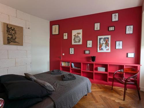 une chambre rouge avec un canapé et un mur rouge dans l'établissement Appartement avec terrasse, jardin et WIFI au cœur historique d'Angoulême - FR-1-653-263, à Angoulême