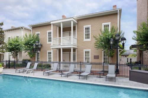 a building with a pool and chairs and a house at Residence Inn Savannah Downtown Historic District in Savannah