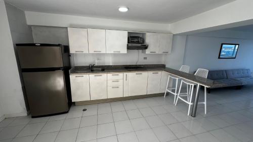 a kitchen with white cabinets and a stainless steel refrigerator at Apartamento frente al mar in Porlamar