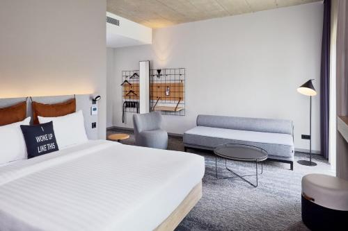 a hotel room with a bed and a couch at Moxy Karlsruhe in Karlsruhe