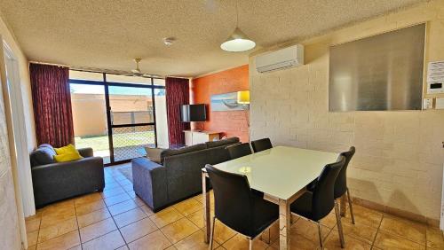 a living room with a table and chairs and a couch at Riverview Holiday Apartment 49 - Kalbarri WA in Kalbarri