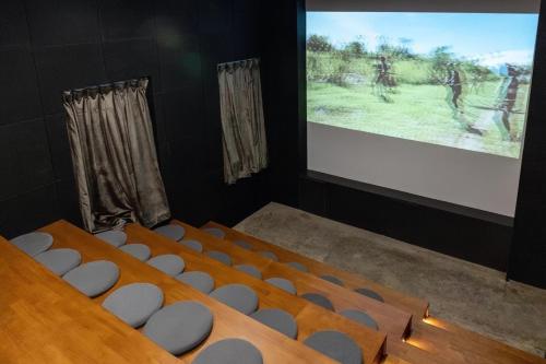 a lecture theatre with a screen and a bunch of chairs at Chongqing Desti Youth Park Hostel Liberation Monument in Chongqing