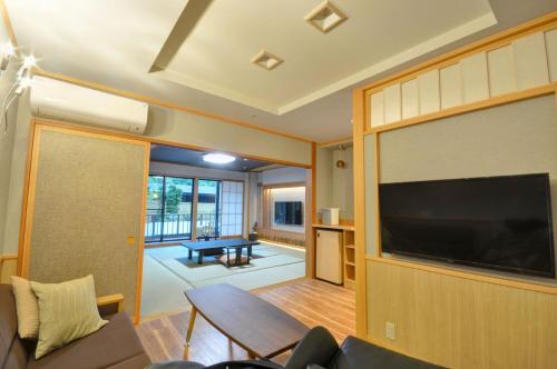 a living room with a large flat screen tv at Hotel Okada in Hakone