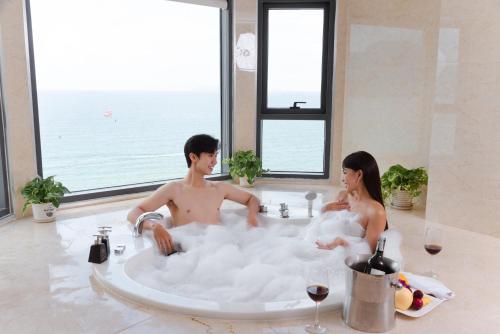 a man and a woman sitting in a bath tub at DLG Hotel Danang in Da Nang