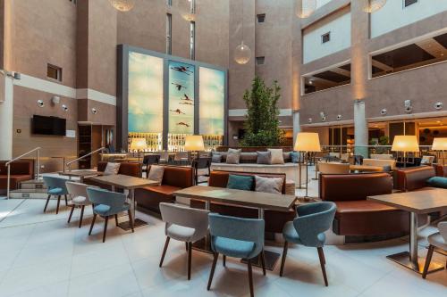 a lobby of a hotel with tables and chairs at Delta Hotels by Marriott Olbia Sardinia in Olbia