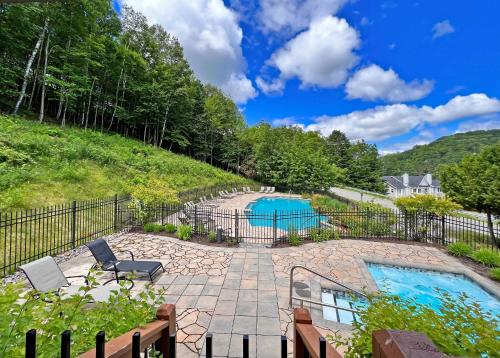 a backyard with a pool and a fence at Le Treehouse by Gestion ELITE in Mont-Tremblant
