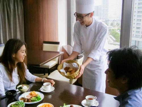 um homem segurando uma cesta de comida ao lado de uma mulher em Hotel Koga Hills (Former: Koga Ark Hotel) em Koga