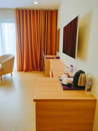 a living room with a table and a television at VISUHA HOTEL in Ha Tien