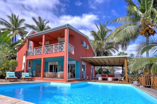 una villa con piscina di fronte a una casa di MAISON DIVON Luxueuse Villa Exotique face à l'Océan avec Piscine chauffée a Bernica-les Bas
