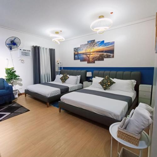 a bedroom with two beds and a couch at Anne's Place at Hope Residences - SMDC Condo Beside SM Trece in Trece Martires