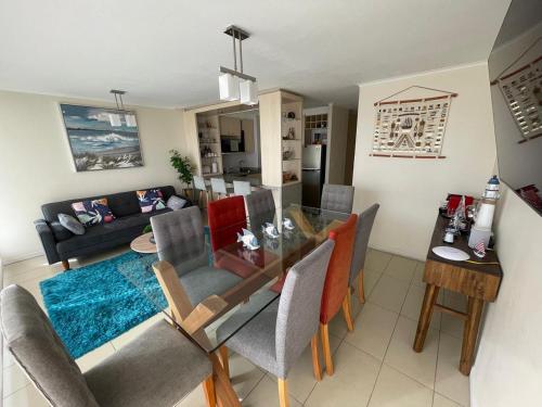 a dining room and living room with a table and chairs at Aqua La Serena primera linea 2 estacionamientos in La Serena