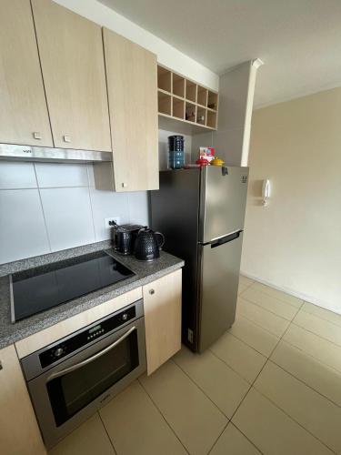 a kitchen with a stainless steel refrigerator and a stove at Aqua La Serena primera linea 2 estacionamientos in La Serena