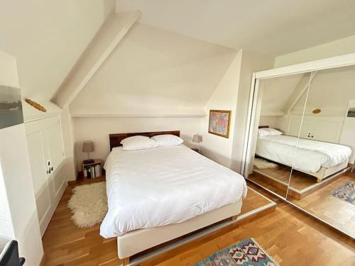 カーンにあるDuplex familial et confortable proche Zénithのベッド2台と大きな鏡のある寝室