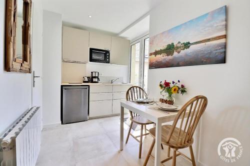 une cuisine et une salle à manger avec une table et des chaises dans l'établissement Le gwenved en broceliande, à Plélan-le-Grand