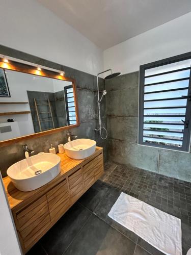 a bathroom with two sinks and a mirror at Villa Eclats Panoramiques in Saint-Pierre