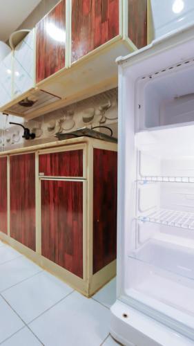 an open refrigerator in a kitchen with red cabinets at رؤى القنفذة للشقق المخدومة in Al Qunfudhah