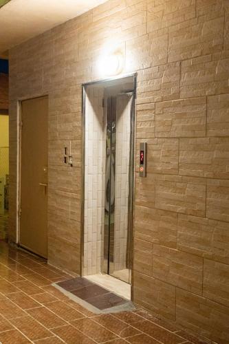 a elevator in a building with a brick wall at رؤى القنفذة للشقق المخدومة in Al Qunfudhah