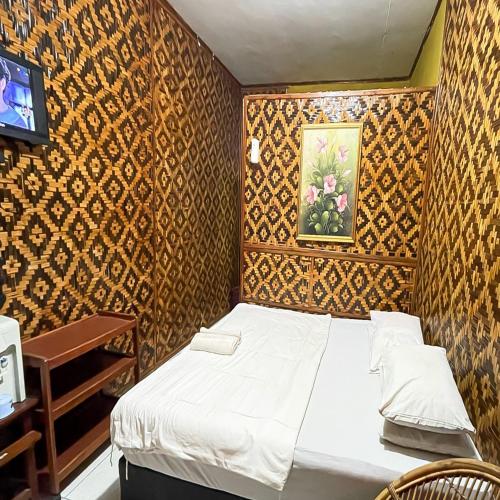 a bedroom with a bed and a painting on the wall at Pondok Yanti Sarii RedPartner in Subang