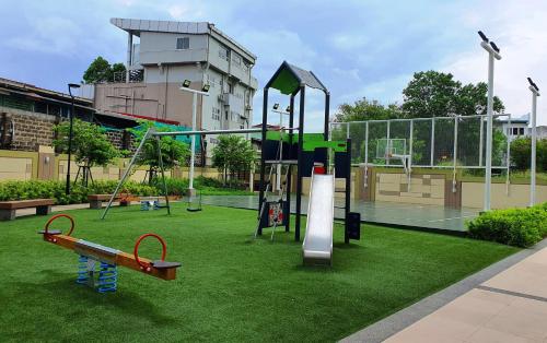 a park with a playground with a tennis court at Cuddle & Cradle Staycation at The Celandine in Manila