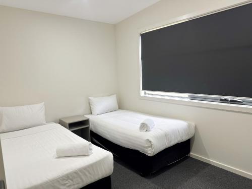 a room with two beds and a large screen at Eastcoaster Tasmania in Orford