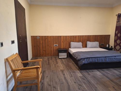 a bedroom with a bed and a chair in it at Jamspal Guest House Ladakh by LexStays in Leh