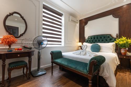 a bedroom with a bed and a chair and a desk at Hoàng Gia Xa La Boutique Hotel in Hanoi