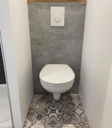 La salle de bains est pourvue de toilettes blanches et de carrelage. dans l'établissement Le Patio, Hyper centre rue au calme avec parking, à Cherbourg en Cotentin