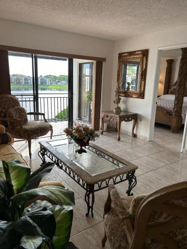 a living room with a coffee table and a balcony at Beautiful apartment with very elegant colonial decoration in Tamiami
