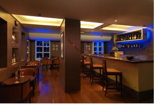 a bar in a restaurant with tables and chairs at Goldfinch Retreat Bangalore in Devanahalli-Bangalore