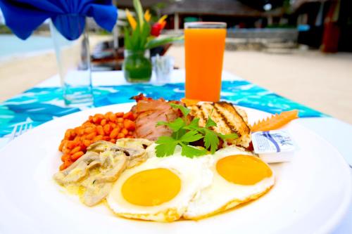 a plate of food with eggs and vegetables on a table at Breakas Beach Resort in Port Vila