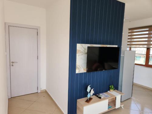 a room with a blue wall with a flat screen tv at APART SUNNY BAY a SUNNY BEACH in Sunny Beach