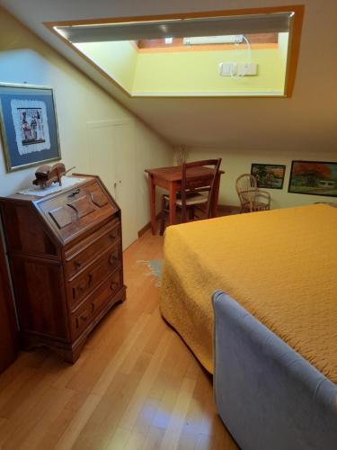 a bedroom with a bed and a dresser and a table at La mansarda di Daniela in Montepulciano Stazione
