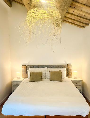 a bedroom with a large white bed with two pillows at Casa Caminate CnC bed&kitchen in Fano