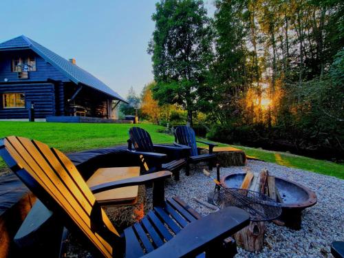 a group of chairs sitting around a fire pit at River House in Nītaure