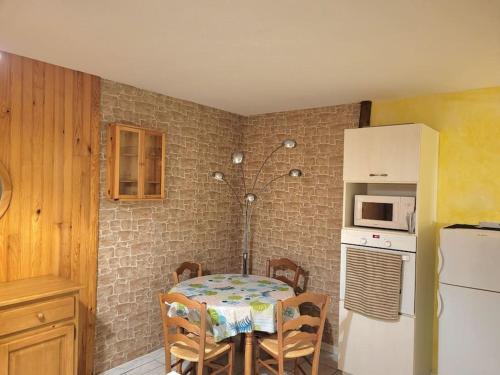 une cuisine avec une table et un réfrigérateur blanc dans l'établissement Appartement T2 terrasse centre-ville, à Digne-Les-Bains